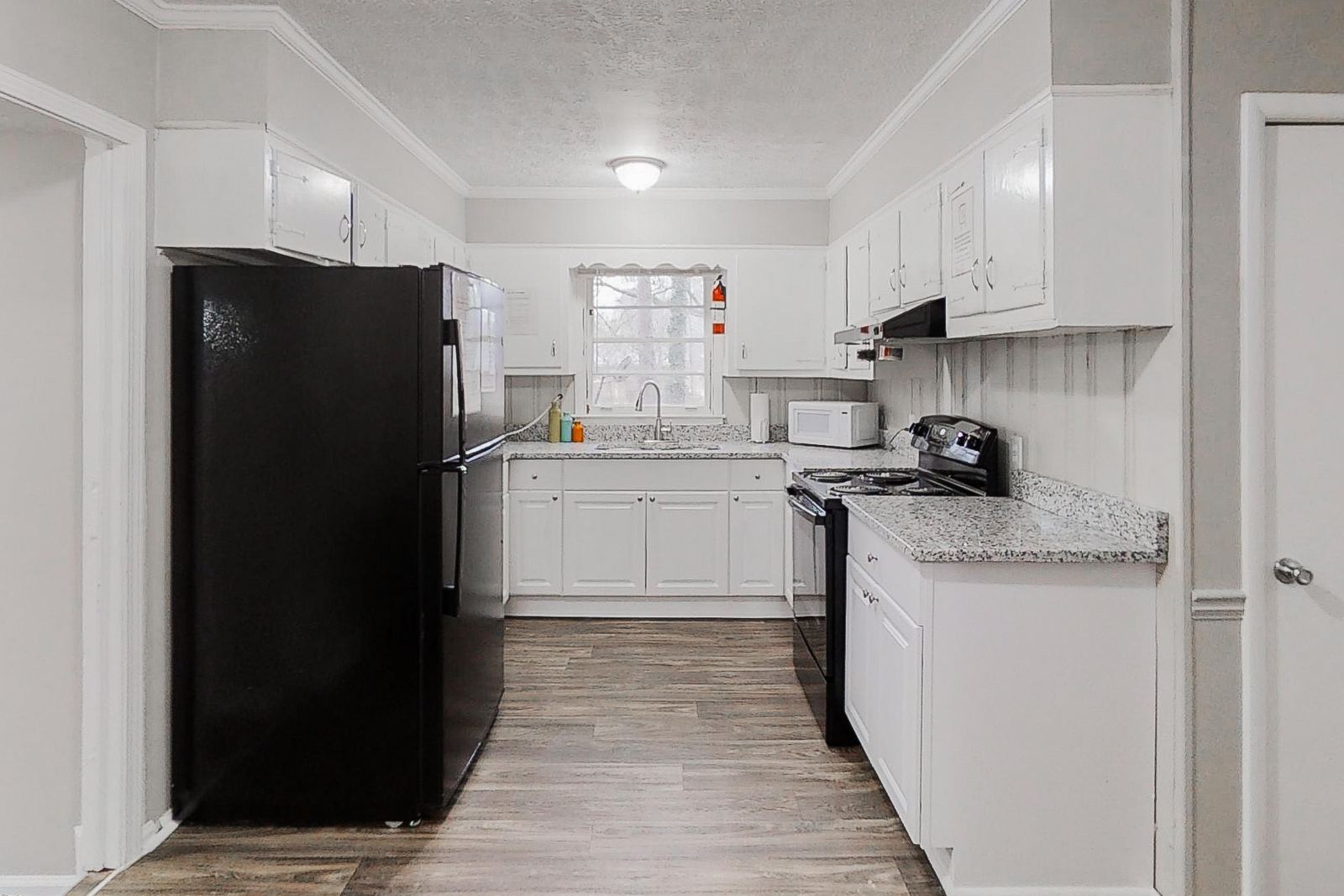 Renovated white kitchen with black appliances