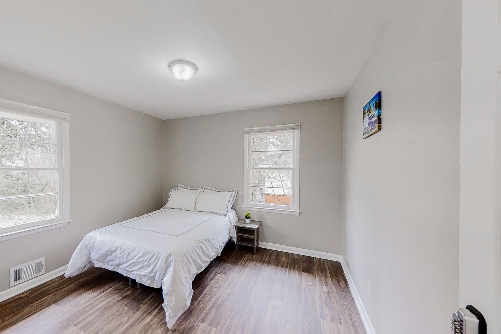 Furnished bedroom with wood-look floors